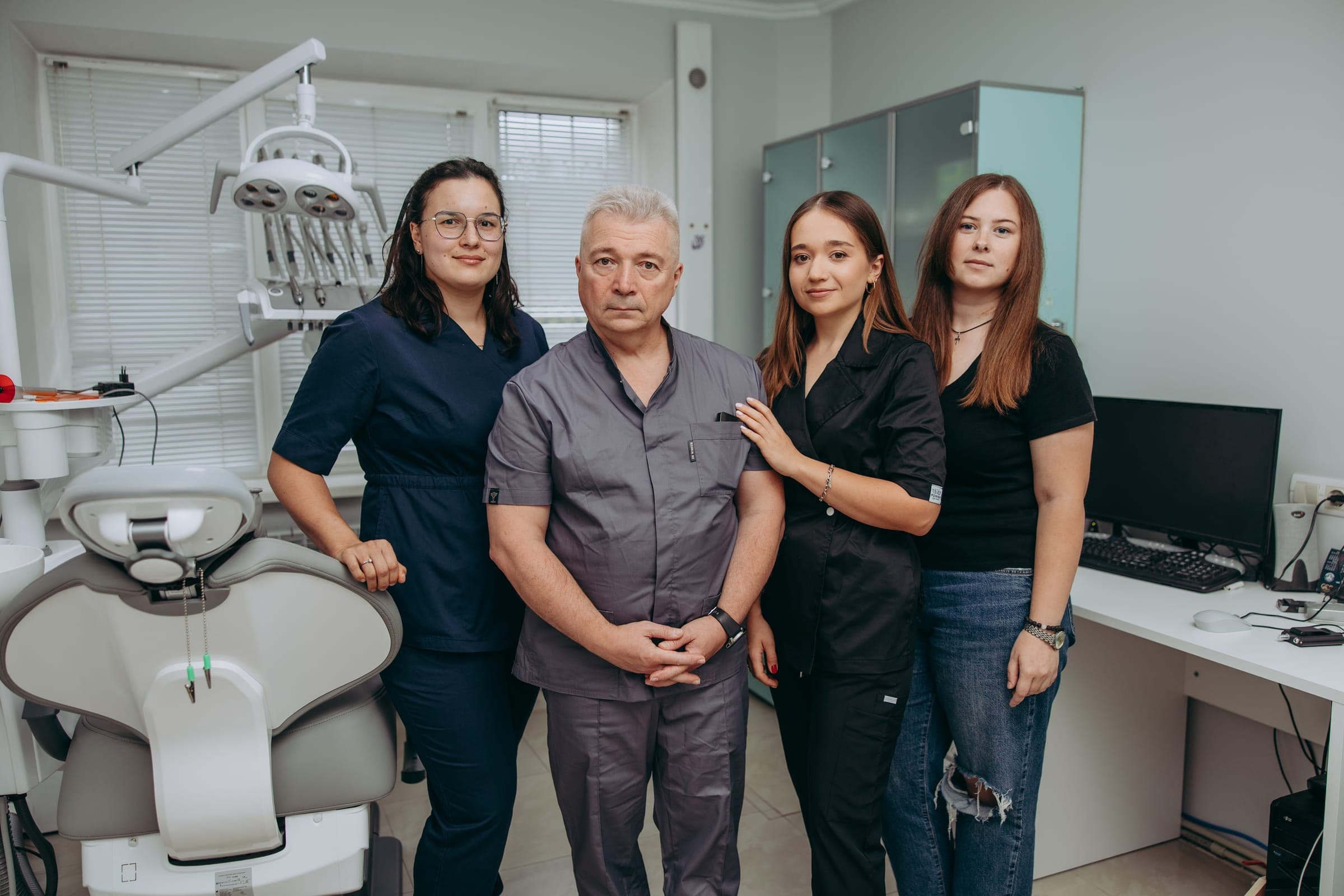 Лікарі та адміністратор Dental Space біля стоматологічної установки в кабінеті клініки